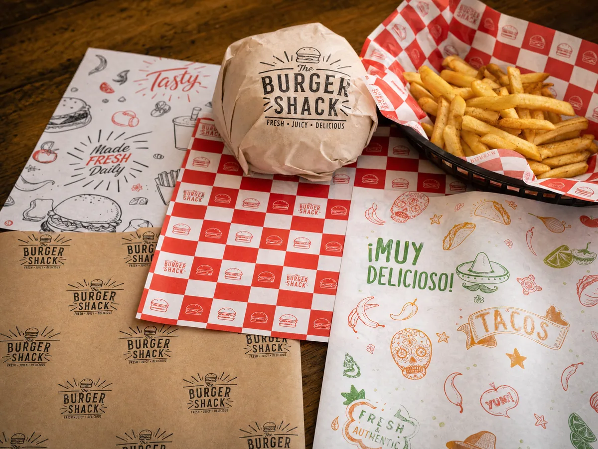 Checkered deli paper lining a food basket with fries and a burger, CupsPak basket liner application