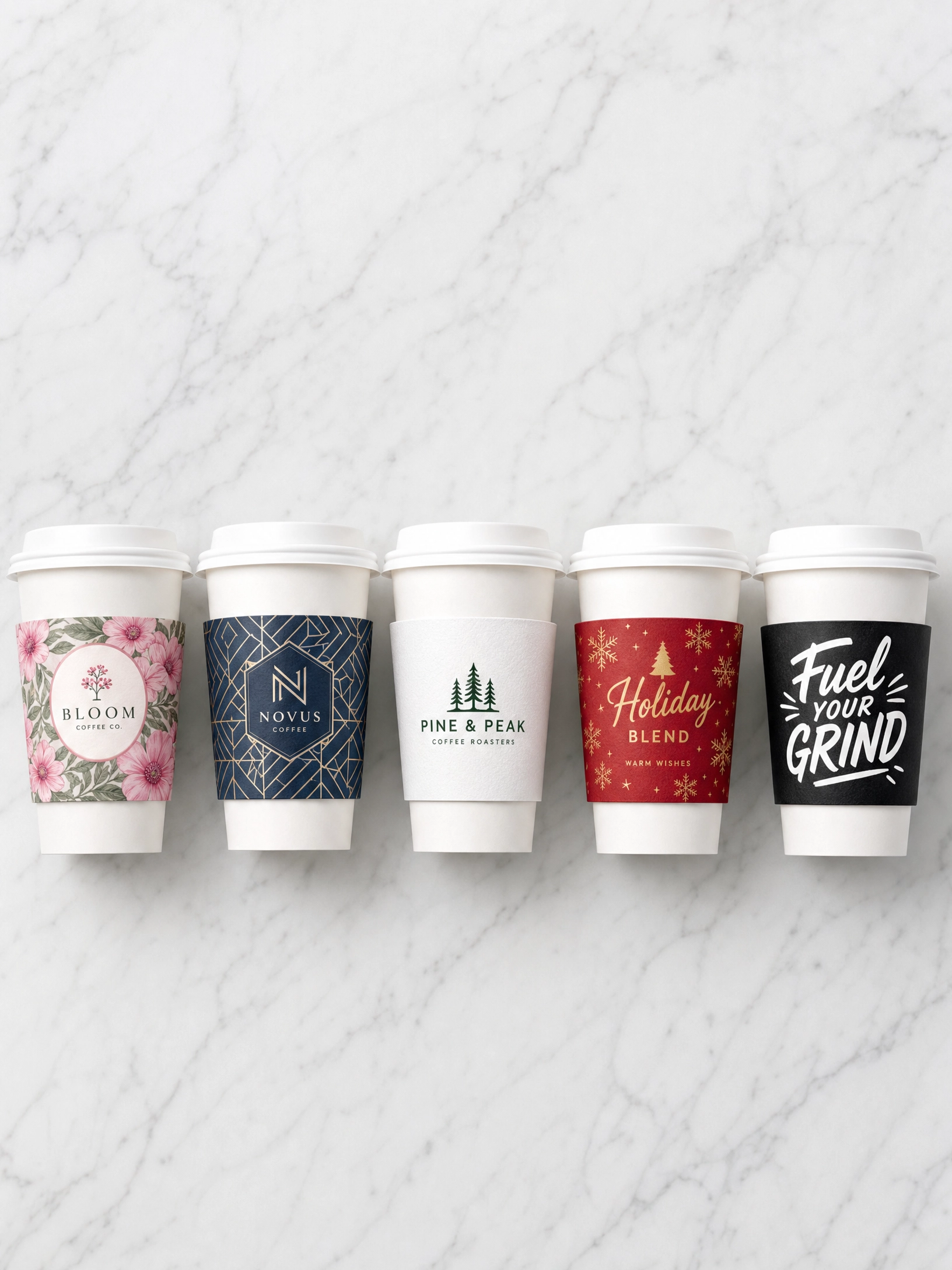 Five custom printed coffee cup sleeves with different brand designs on white paper cups arranged in a row on a marble surface