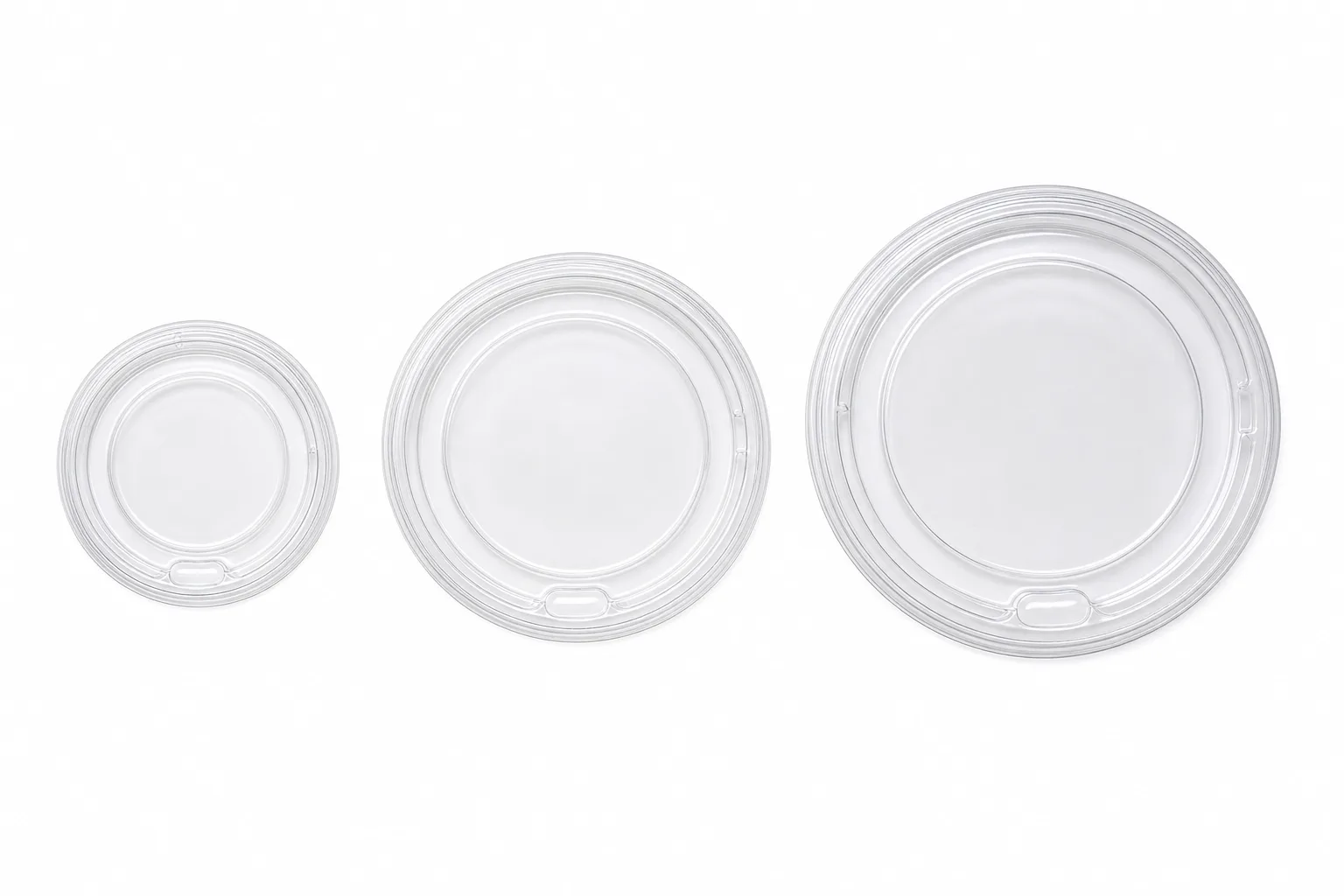 Three clear flat portion cup lids side by side in small, medium and large diameters, the three lid sizes that cover all seven cups